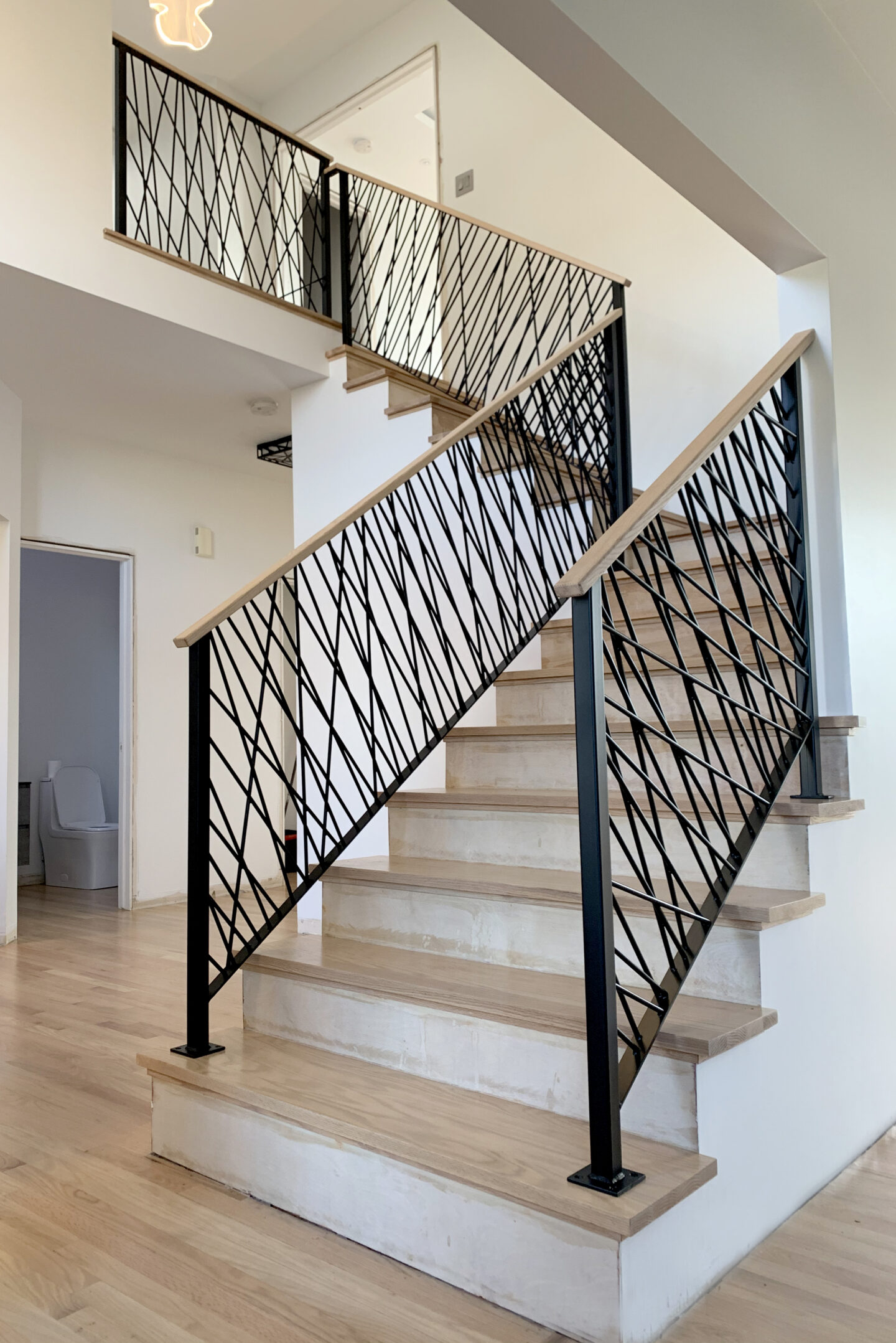 Custom wrought iron & wood railings art deco painted satin black bottom stairwell view