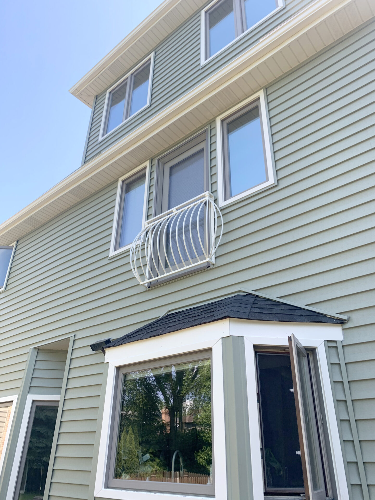 Transitional belly wrought iron balcony painted white